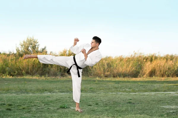 Młody mężczyzna na zewnątrz ćwiczyć karate — Zdjęcie stockowe
