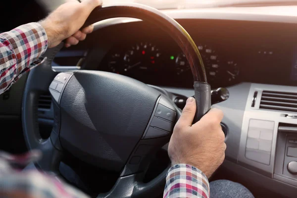 Junger Mann hält Hand am Lenkrad des Autos — Stockfoto