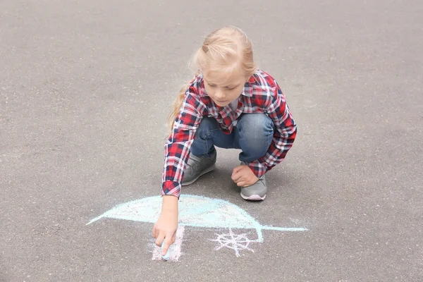 Little girl drawing ship with chalk on asphalt — Stock Photo, Image