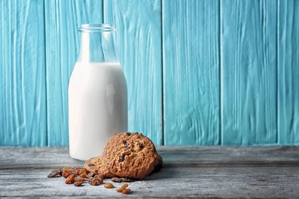 Delicious oatmeal cookies with raisins and bottle of milk — Stock Photo, Image