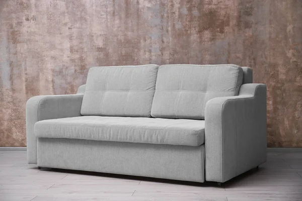 Удобный диван против стены — стоковое фото