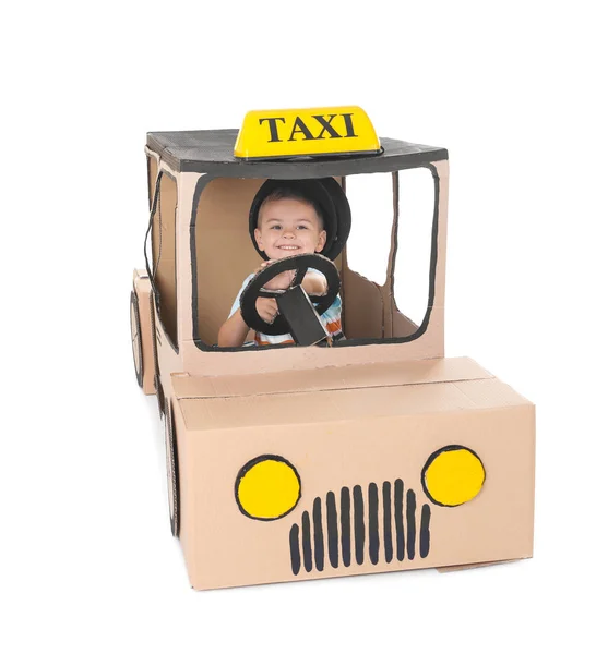 Kleiner Junge spielt mit Papptaxi auf weißem Hintergrund — Stockfoto