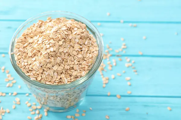 Vaso con harina de avena cruda en la mesa —  Fotos de Stock