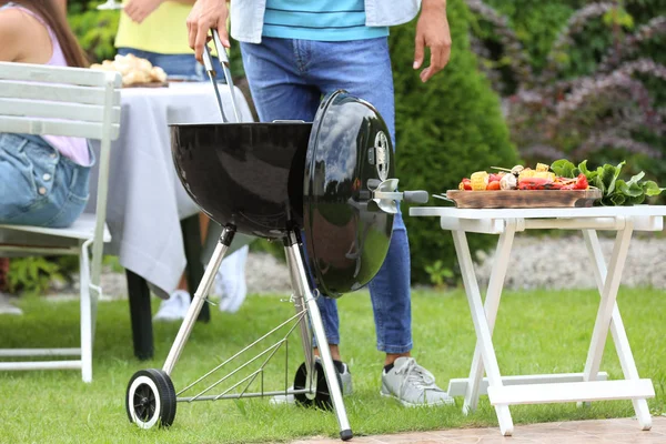 Homem cozinhar comida saborosa na churrasqueira, ao ar livre — Fotografia de Stock