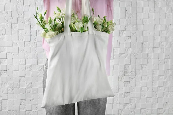 Bolso de mujer con hermosas flores eustoma sobre fondo de ladrillo — Foto de Stock