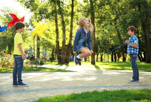 Leuke lieve kinderen springtouw in park — Stockfoto