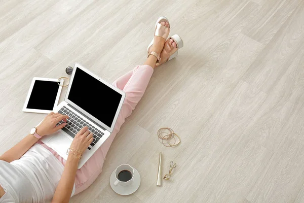 Junge Beauty-Bloggerin benutzt Laptop während sie auf dem Boden sitzt — Stockfoto