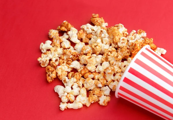 Overturned cup with tasty caramel popcorn — Stock Photo, Image