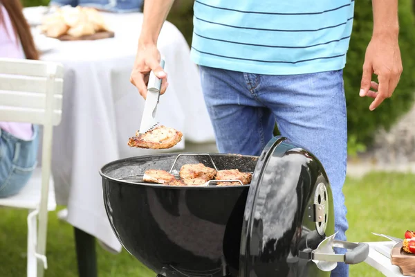 Man grill matlagning läckra biffar på grill, Utomhus — Stockfoto