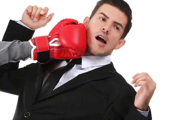 Hand of woman in boxing glove hitting businessman on white background — Stock Photo, Image