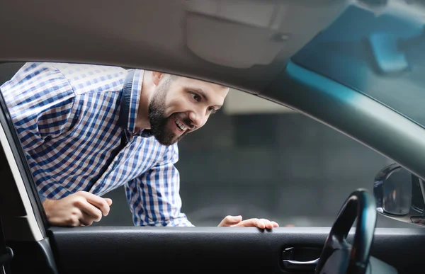 Jeune homme regardant salon de voiture — Photo