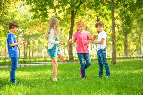 Cute little children jumping rope in park — Stock Photo, Image