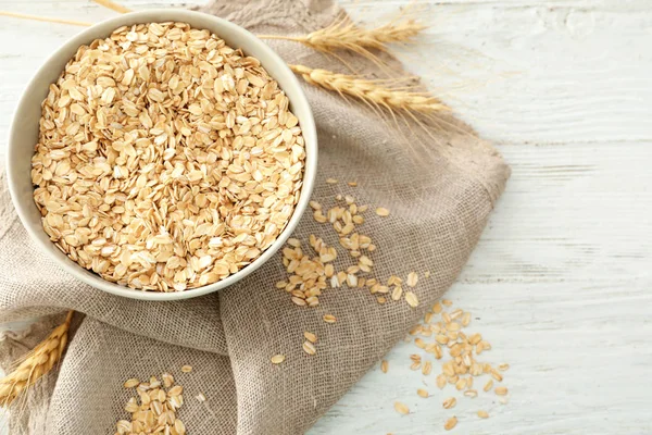 Ciotola con farina d'avena cruda in tavola — Foto Stock