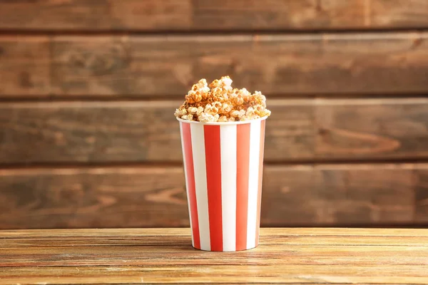 Cup with tasty caramel popcorn — Stock Photo, Image