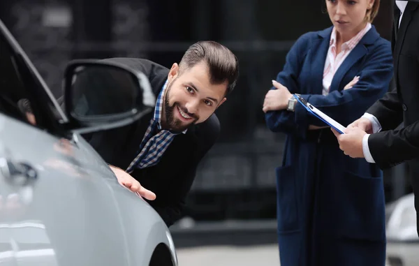Молодой человек смотрит на автомобиль на улице — стоковое фото