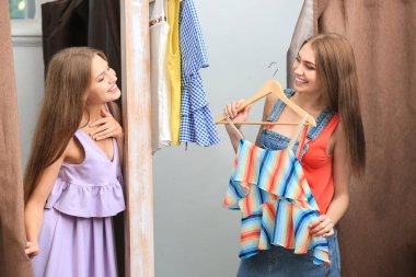 Genç kadın kıyafetlerini soyunma odaları üzerinde çalışıyor