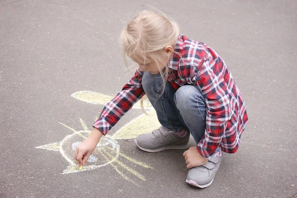 Little girl drawing cat with chalk on asphalt — Stock Photo, Image