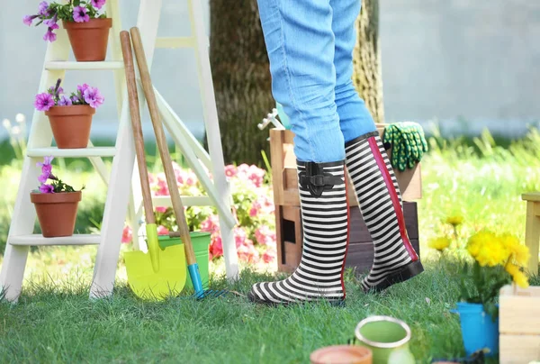 Femme debout près des outils de jardinage dans la cour arrière — Photo