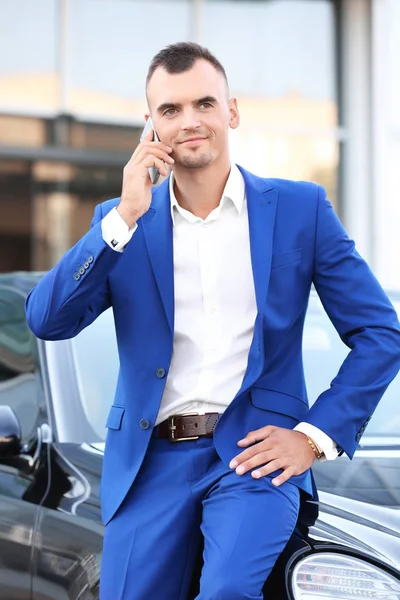 Młody biznesmen rozmowy na telefon w pobliżu samochodu — Zdjęcie stockowe