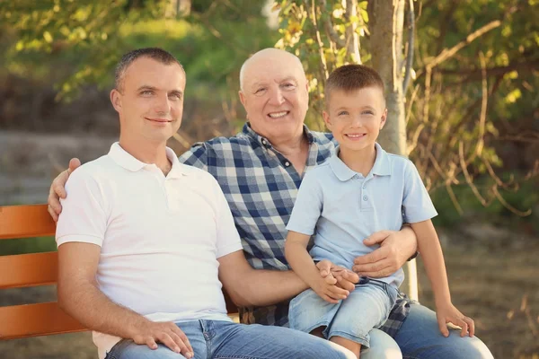 Anak kecil dengan ayah dan kakek duduk di bangku taman — Stok Foto