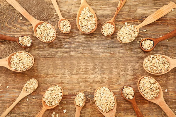 Frame made of spoons with raw oatmeal — Stock Photo, Image