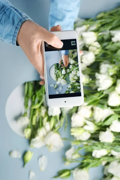 Blogger biorąc zdjęcie eustoma kwiatów z telefonu komórkowego — Zdjęcie stockowe