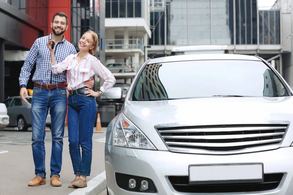 Young couple standing near car outdoors — Stock Photo, Image