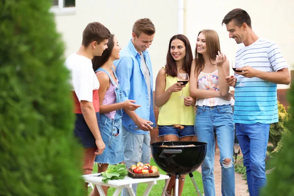 Молоді друзі проводять вечірку барбекю в саду — стокове фото