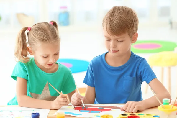 Милі діти малюють за столом в приміщенні — стокове фото