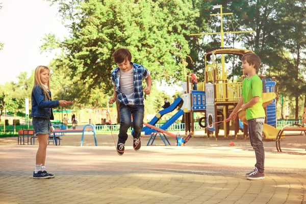 Leuke lieve kinderen springtouw in park — Stockfoto