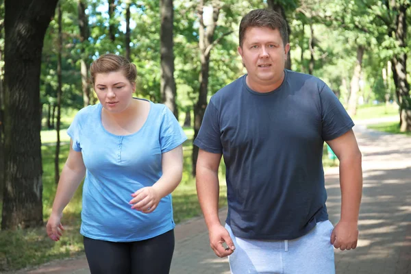 Overweight couple running in green park — Stock Photo, Image