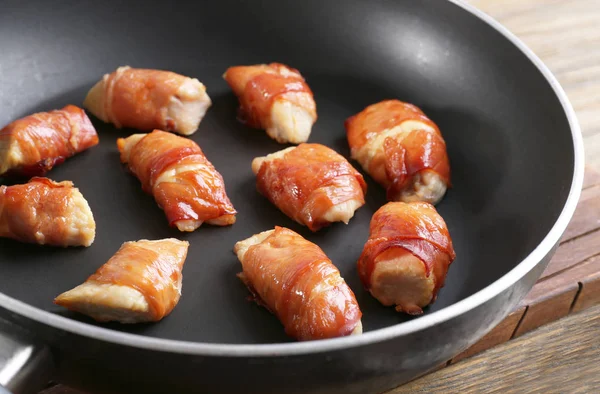 Bacon wrapped chicken in frying pan — Stock Photo, Image