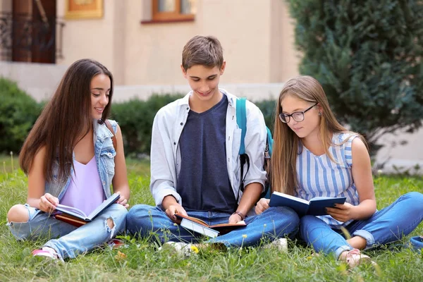 Students reading books outdoors — Stock Photo, Image