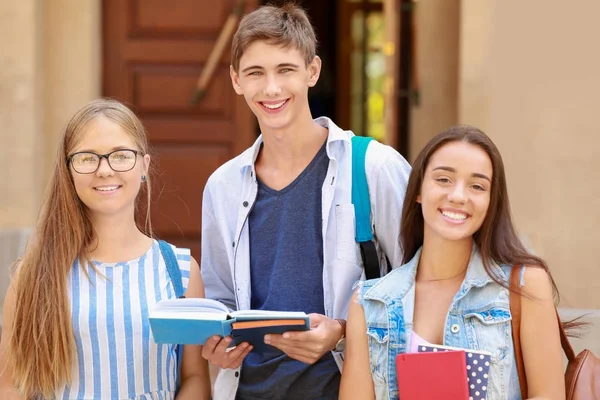 Studenter med copybooks stående utomhus — Stockfoto