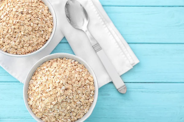 Bowls with raw oatmeal on table — Stock Photo, Image