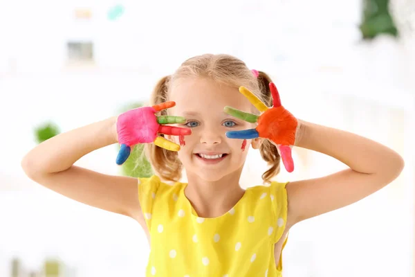 Schattig meisje met paint op handen tegen onscherpe achtergrond — Stockfoto