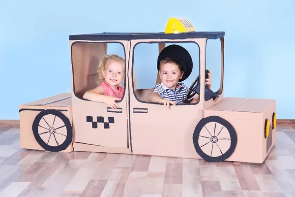 Kicsinyeim, játszó karton taxi világos szobában — Stock Fotó