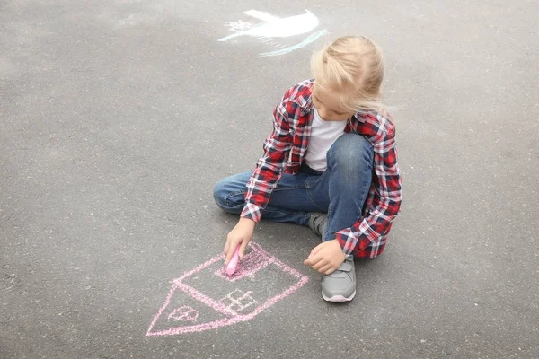 Little girl drawing house with chalk on asphalt — Stock Photo, Image