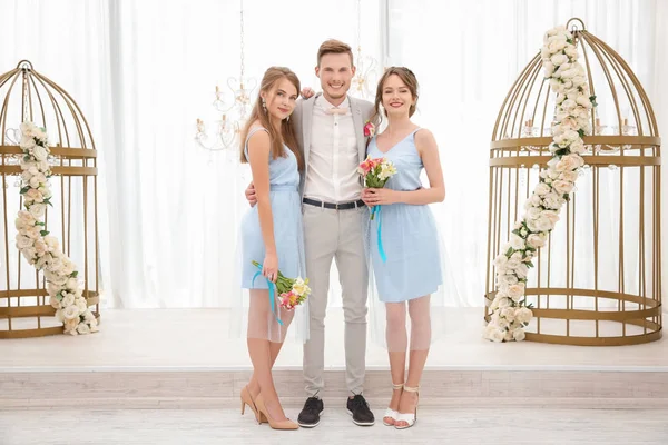 Gelukkig knappe bruidegom met bruidsmeisjes op trouwdag, binnenshuis — Stockfoto