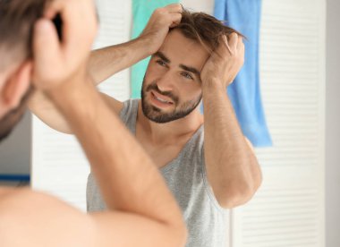 Genç adam evde akşamdan kalma acı sabahında