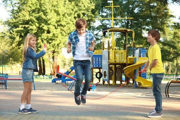 逗人喜爱的小孩子跳绳在公园 — 图库照片