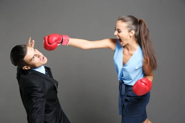 Mujer en guantes de boxeo golpeando hombre de negocios —  Fotos de Stock