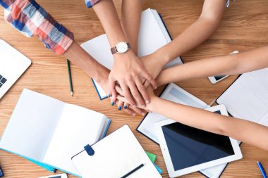 öğrencilerin ellerini koyarak 