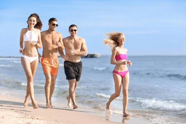 Groupe de jeunes gens attrayants sur la plage — Photo