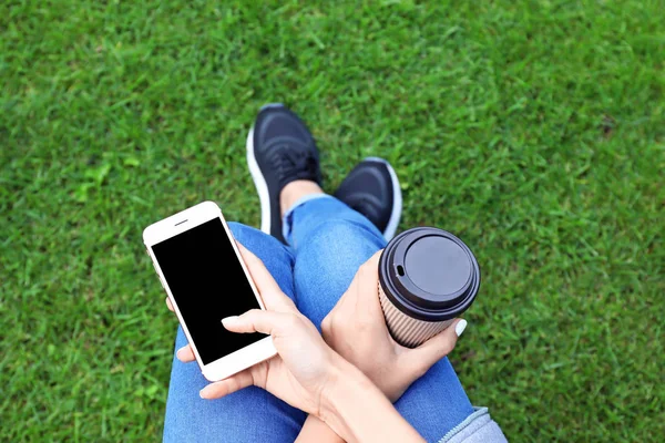 Donna con cellulare e tazza di caffè — Foto Stock