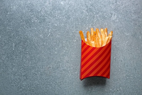 Papperskasse med smaskiga pommes frites — Stockfoto