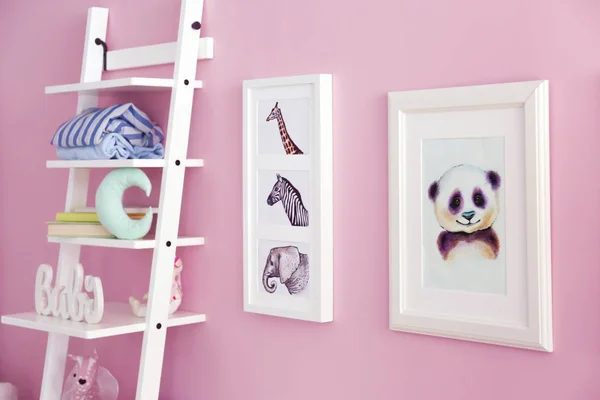 Rekken met speelgoed en foto's van dieren op de muur in de kamer van de baby — Stockfoto