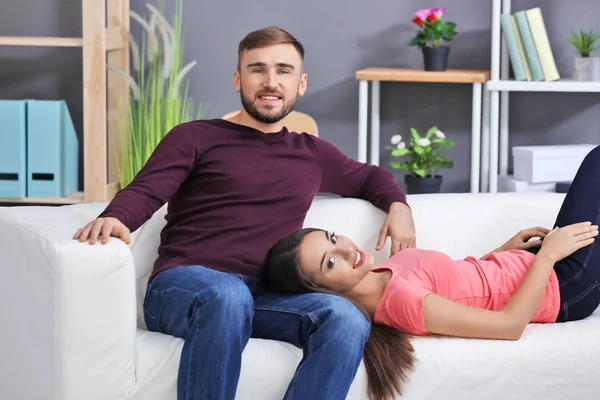 Joven pareja en sofá — Foto de Stock