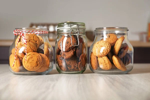 Glass jars with delicious oatmeal cookies — Stock Photo, Image