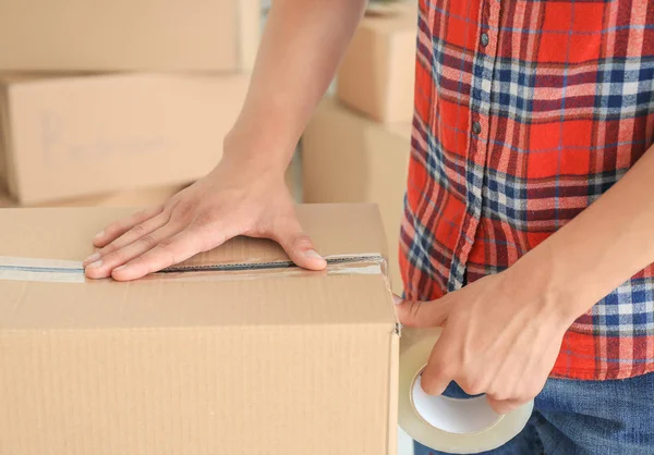 Ung man packbox, inomhus — Stockfoto